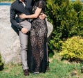 Young couple woman in a long elegant lace black dress man in trousers and shirt. love story outdoors, tenderness, hugs Royalty Free Stock Photo