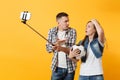 Young couple, woman man, football fans doing selfie on mobile phone with monopod selfish stick, cheer up support team Royalty Free Stock Photo