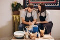 Young couple, woman and man, are working in pottery studio, having nice time together, woman is making item from raw Royalty Free Stock Photo