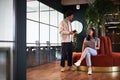 Young couple in work space for start up business have meeting in seating area of open plan office Royalty Free Stock Photo