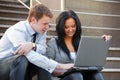 Young business couple using laptop on the steps Royalty Free Stock Photo