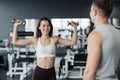 Young couple is working out at gym. Attractive woman and handsome muscular man trainer are training in light modern gym. Beautiful Royalty Free Stock Photo