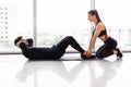 Young couple is working out at gym. Attractive woman and handsome muscular man are training sits up in gym. Abs exercises Royalty Free Stock Photo