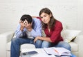 Young couple worried home in stress wife comforting husband accounting debt unpaid bills bank papers expenses Royalty Free Stock Photo