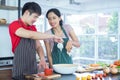 Young Couples Asian. They both look each other`s eyes. Smile, Cooking so fun together in kitchen