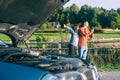 Young couples car broke down on the way. They hitchhike to find help Royalty Free Stock Photo