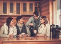 Young couples drinking hot tea in winter cottage kitchen. Royalty Free Stock Photo