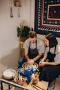 Young couples that enjoy making clay sculptures. Using pottery and assisting one another to create flower vases out of