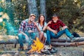 Young couples having picnic in woods. Young people having a camping. Company friends enjoy relaxing together in forest Royalty Free Stock Photo