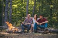 Young couples having picnic in woods. Romantic picnic forest. Young people having a camping. Spring or autumn camping Royalty Free Stock Photo