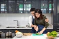 Young couples are helping to chop vegetables in the kitchen. Asian couple cooking together at the kitchen Royalty Free Stock Photo