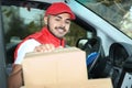 Young courier checking amount of parcels