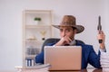 Young cowboy businessman working at workplace