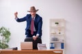 Young cowboy businessman working at workplace