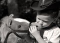 Young cowboy kissing his horse