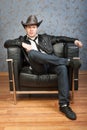 Young cowboy sitting in leather chair