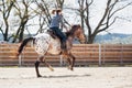 Young cowgirl riding a beautiful paint horse in a barrel racing event at a rodeo. Royalty Free Stock Photo