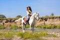 Young cowgirl on white horse at the river Royalty Free Stock Photo