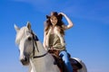 Young cowgirl on white horse smile