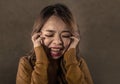 Young crazy desperate and upset Asian Korean woman screaming scared and anxious feeling anger and pain isolated on dark background