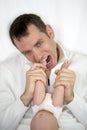 Young crazy father is loosing patience with baby and ready to bite her feet. Royalty Free Stock Photo