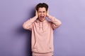 Young crazy funny emotional man covering his ears and shouting. Royalty Free Stock Photo