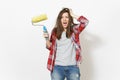 Young crazy loony woman in casual clothes holding paint roller for wall painting and clinging to head isolated on white Royalty Free Stock Photo