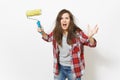 Young crazy loony woman in casual clothes holding paint roller for wall painting and screaming isolated on white