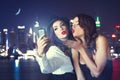 Young crazy girlfriends taking selfie at night in city