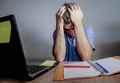 Young crazy stressed and overwhelmed man working messy at office desk desperate with laptop computer covering face with hands frus Royalty Free Stock Photo