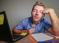Young crazy stressed and overwhelmed man working messy at office desk desperate with laptop computer feeling exhausted and frustra Royalty Free Stock Photo