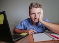 Young crazy stressed and overwhelmed man working messy at office desk desperate with laptop computer suffering depression frustrat