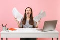 Young Crazy woman screaming spreading hand holding paper documents working on project while sitting at office with Royalty Free Stock Photo