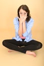 Young Crazy Woman Sitting on the Floor Pulling Silly Facial Expression Royalty Free Stock Photo