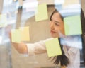 Young creative Asian woman use post it notes for reminder. Royalty Free Stock Photo