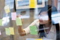 Young creative Asian woman use post it notes for reminder. Royalty Free Stock Photo