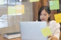 Young creative Asian woman working in modern office.