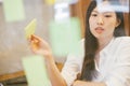 Young creative Asian woman working in modern office. use post it for meeting. Royalty Free Stock Photo