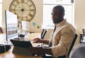 Young creative black man working on computer in modern office at desk on tablet computer Royalty Free Stock Photo