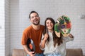 Young creative couple, artists musician and painter holding LP and colors palette with painting brush. Home of artwork Royalty Free Stock Photo