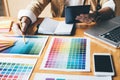 Young creative Graphic designer using graphics tablet to choosing Color swatch samples chart for selection coloring with work too Royalty Free Stock Photo