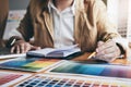 Young creative Graphic designer using graphics tablet to choosing Color swatch samples chart for selection coloring with work Royalty Free Stock Photo