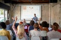 A young creative man is answering questions while holding a presentation to his colleagues at conference room. Employees, office, Royalty Free Stock Photo