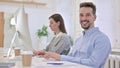 Young Creative Man working on Desktop and Smiling at the Camera Royalty Free Stock Photo