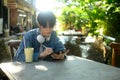 Young creative man working on his digital tablet in a cozy outdoor cafe Royalty Free Stock Photo