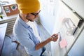 Young creative man writing down ideas on wall full of sticky notes. Royalty Free Stock Photo