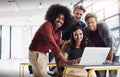 Young, creative and successful. Portrait of a team of happy designers working around a laptop in their modern office. Royalty Free Stock Photo