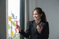 Young creative woman professional using sticky notes in glass wall to writing strategy business plan to development grow Royalty Free Stock Photo