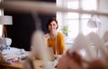 Young creative woman in a studio, using laptop. A startup of tailoring business. Royalty Free Stock Photo