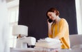 Young creative woman in a studio, using smartphone. A startup of tailoring business. Royalty Free Stock Photo